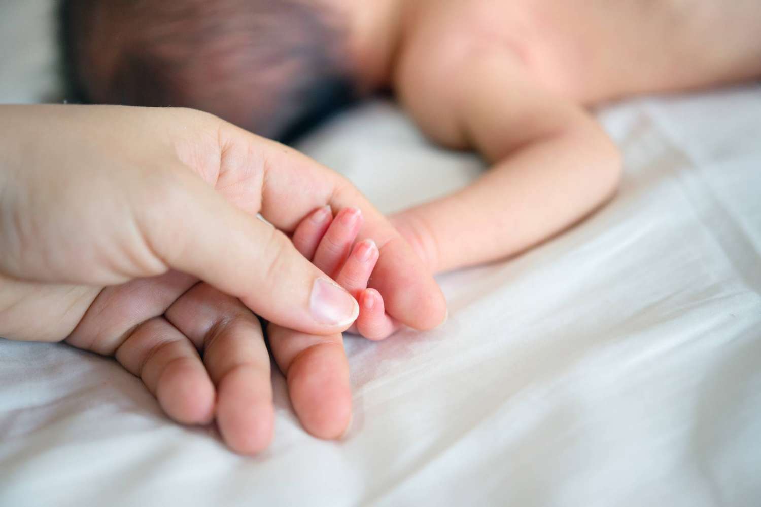 Новорожденный на руках. Ладонь новорожденного. Младенец на руках съеживается. Младенец ощупывание своих рук.